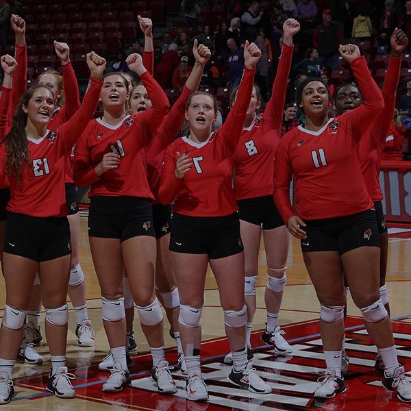 Volleyball players on the court singing the fight song.